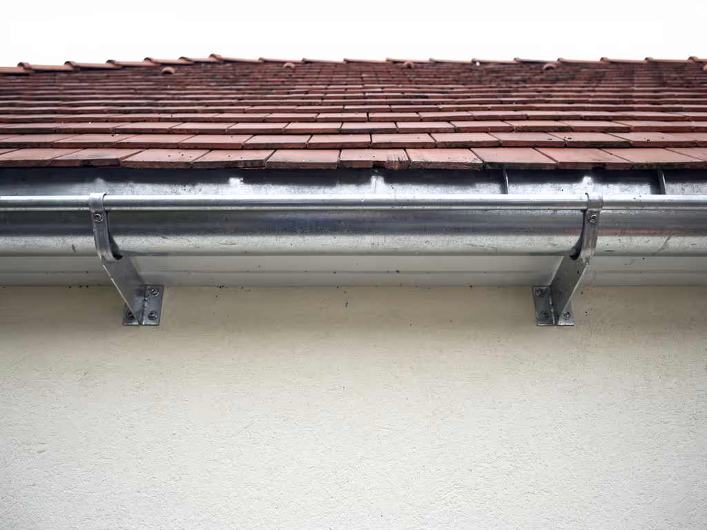 Neu montierte Zinkrinne an einem Lehel-Altbau mit Stuckfassade