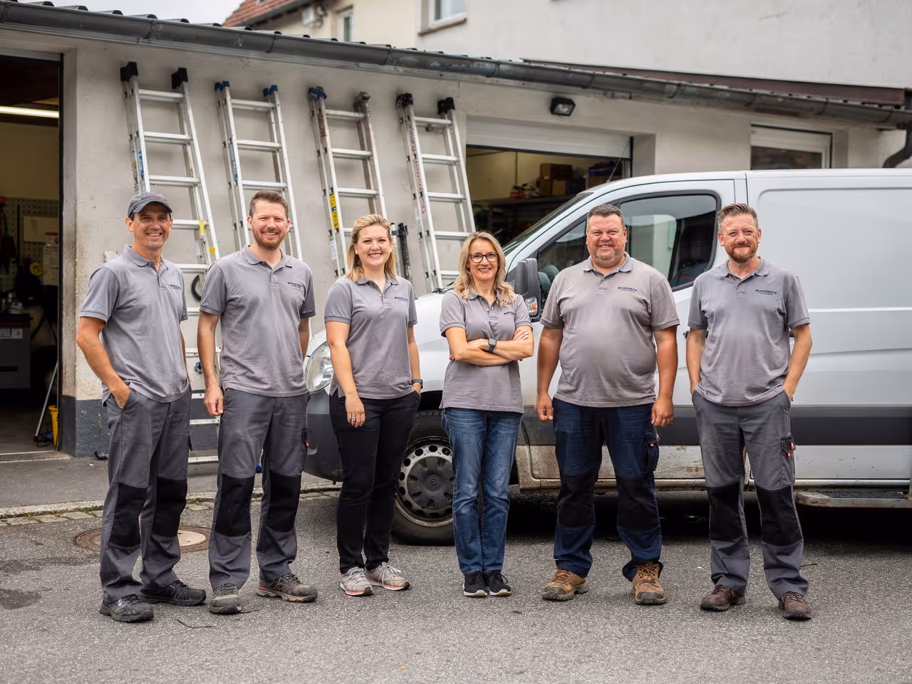 Das Team von Dachrinnenprofi München an den Servicefahrzeugen in Bogenhausen